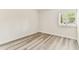Empty bedroom shows light-colored laminate flooring, a window with plantation shutters, and white walls at 36750 Us 19 N # 08102, Palm Harbor, FL 34684