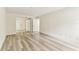 Unfurnished bedroom shows light-colored laminate flooring with white doors and entry to hall at 36750 Us 19 N # 08102, Palm Harbor, FL 34684