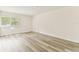 Empty bedroom shows light-colored laminate flooring, a window with plantation shutters, and white walls at 36750 Us 19 N # 08102, Palm Harbor, FL 34684