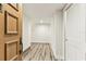 Bright hallway featuring wood-look floors and white walls with a wooden door at 36750 Us 19 N # 08102, Palm Harbor, FL 34684