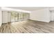 Spacious living room featuring wood-look floors and white shutter doors at 36750 Us 19 N # 08102, Palm Harbor, FL 34684