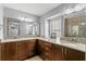 Bathroom with granite counters, double sinks, wooden cabinets, and a framed mirror at 4506 W Beachway Dr, Tampa, FL 33609