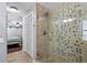 Bathroom boasts tiled shower, glass door, tile floors, and convenient access to the primary bedroom at 4506 W Beachway Dr, Tampa, FL 33609