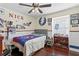 Cozy bedroom with hardwood floors, ceiling fan, and walls adorned with sports memorabilia at 4506 W Beachway Dr, Tampa, FL 33609