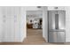 Hallway view into living room, featuring hardwood floors and access to stainless steel refrigerator at 4506 W Beachway Dr, Tampa, FL 33609
