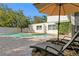 Relaxing poolside with lounge chairs and umbrella, offering a perfect outdoor retreat at 4506 W Beachway Dr, Tampa, FL 33609