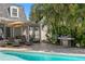 Backyard oasis featuring a sparkling pool, outdoor kitchen, and lush tropical landscaping at 4506 W Beachway Dr, Tampa, FL 33609