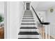 Bright staircase with white risers, black treads, and black handrail complements neutral decor at 4506 W Beachway Dr, Tampa, FL 33609