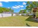 Large backyard with white fence, manicured lawn and mature trees at 501 61St Ne Ave, St Petersburg, FL 33703