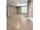 Spacious living room with neutral tile flooring, bright window and simple base trim at 5014 Bella Armonia Cir, Wimauma, FL 33598