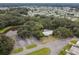 An aerial view of a clubhouse and parking surrounded by trees, a pond and a residential neighborhood at 5546 Benton St, Zephyrhills, FL 33542