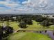 Scenic aerial view of the golf course with trees, pond and golf cart trails on a partly cloudy day at 5546 Benton St, Zephyrhills, FL 33542