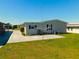 Backyard with grass, a clothesline, and landscaping near the house at 5546 Benton St, Zephyrhills, FL 33542