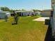 Grassy backyard view showing a minimal lawn, utility connections, and neighboring homes at 5546 Benton St, Zephyrhills, FL 33542
