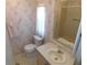 Compact bathroom with floral wallpaper, vanity, toilet and walk-in shower at 5546 Benton St, Zephyrhills, FL 33542