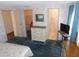 Bright bedroom featuring floral wallpaper, carpeted floor, TV and two closets at 5546 Benton St, Zephyrhills, FL 33542