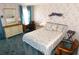 Calm bedroom with floral wallpaper and blue carpet, with desk and natural lighting at 5546 Benton St, Zephyrhills, FL 33542