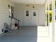 Covered carport and entrance with double doors and a small landing with a handrail at 5546 Benton St, Zephyrhills, FL 33542