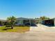 Well-maintained single-story home with mature landscaping, a carport, and a concrete driveway at 5546 Benton St, Zephyrhills, FL 33542