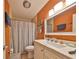 Well-lit bathroom featuring a marble vanity top, framed mirror, and shower with striped curtain at 672 Allegheny Dr, Sun City Center, FL 33573