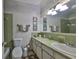 Classic bathroom features a vintage green tile, framed art, and a large mirror at 672 Allegheny Dr, Sun City Center, FL 33573