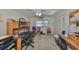 Carpeted bedroom with ceiling fan, closet, two windows, and built-in desk with cabinetry at 672 Allegheny Dr, Sun City Center, FL 33573