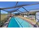 Spacious screened pool with a lounge area, overlooking manicured greenbelt views at 672 Allegheny Dr, Sun City Center, FL 33573