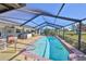 Inviting screened pool with poolside seating and lush landscaping, ideal for summer enjoyment at 672 Allegheny Dr, Sun City Center, FL 33573