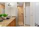 Bathroom with granite vanity, dual sinks, and walk-in shower with a tile surround at 705 S West Shore Blvd, Tampa, FL 33609