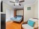 Bedroom featuring a Murphy bed, hardwood flooring, and a ceiling fan with wicker seating at 705 S West Shore Blvd, Tampa, FL 33609