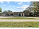 Charming single-story home with a red front door, well-manicured lawn, and mature trees at 705 S West Shore Blvd, Tampa, FL 33609