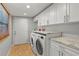 Well-lit laundry room featuring a washer and dryer, granite countertops, and ample cabinet space at 705 S West Shore Blvd, Tampa, FL 33609