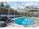 Beautiful pool with waterfall feature, surrounded by a screened enclosure and lush landscaping at 705 S West Shore Blvd, Tampa, FL 33609