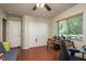 Bright bedroom featuring hardwood floors, a ceiling fan, and a large window with a view of the outdoors at 7182 Griffin Rd, Brooksville, FL 34601