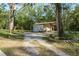 View of an outbuilding that includes an awning, and a garage door, surrounded by an open lot at 7182 Griffin Rd, Brooksville, FL 34601