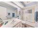 Bright bathroom featuring a large mirror, white vanity, and a glass-enclosed shower/tub combination at 8066 Brentwood Rd # 8066, Seminole, FL 33777