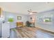 Light-filled bedroom with wood-look flooring, multiple windows, a ceiling fan, and a comfortable workspace at 8066 Brentwood Rd, Seminole, FL 33777