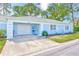 Charming blue home with a garage and well-maintained landscaping, creating a welcoming curb appeal at 8066 Brentwood Rd # 8066, Seminole, FL 33777