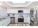 Bright kitchen with white cabinets, stainless steel appliances, and wood-look flooring at 8066 Brentwood Rd # 8066, Seminole, FL 33777