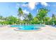 Community swimming pool features a unique shape with plenty of lounge chairs and greenery at 8066 Brentwood Rd # 8066, Seminole, FL 33777