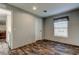 Bedroom with wood-look flooring, view to dining area, and window with curtains at 9420 Kiowa Dr, New Port Richey, FL 34654