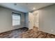 Bedroom featuring wood-look floors, neutral walls, window with shade, and doorway to ensuite bathroom at 9420 Kiowa Dr, New Port Richey, FL 34654