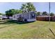 Exterior view of the home featuring a grassy yard and wood fence at 9420 Kiowa Dr, New Port Richey, FL 34654