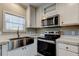 Modern kitchen appliances, including a microwave and oven, complemented by white cabinets at 9420 Kiowa Dr, New Port Richey, FL 34654
