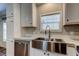 Close-up of the stainless steel farmhouse sink, white cabinets, and elegant countertops at 9420 Kiowa Dr, New Port Richey, FL 34654