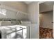 Bright laundry room with washer, dryer, wire shelving, and view to wood-look floors beyond at 9420 Kiowa Dr, New Port Richey, FL 34654
