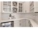 Stylish bar area with white cabinets, wine rack, and elegant glassware at 9825 Autumn Ridge Ave, Riverview, FL 33578