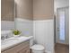 Bright bathroom featuring white wainscoting, a sleek vanity, and a neutral color palette, creating a serene and modern space at 9825 Autumn Ridge Ave, Riverview, FL 33578