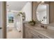 Neutral bathroom featuring a stylish vanity, a large mirror, and views of the bedroom space, enhancing the room's openness at 9825 Autumn Ridge Ave, Riverview, FL 33578