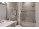 Well-lit bathroom features a tub/shower combination, vanity, and neutral tiling at 9825 Autumn Ridge Ave, Riverview, FL 33578